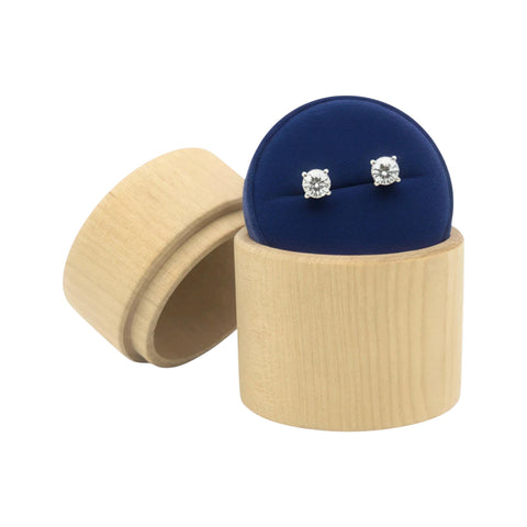 pair of diamond stud earrings in a turned round wooden jewelry box on a beige stand